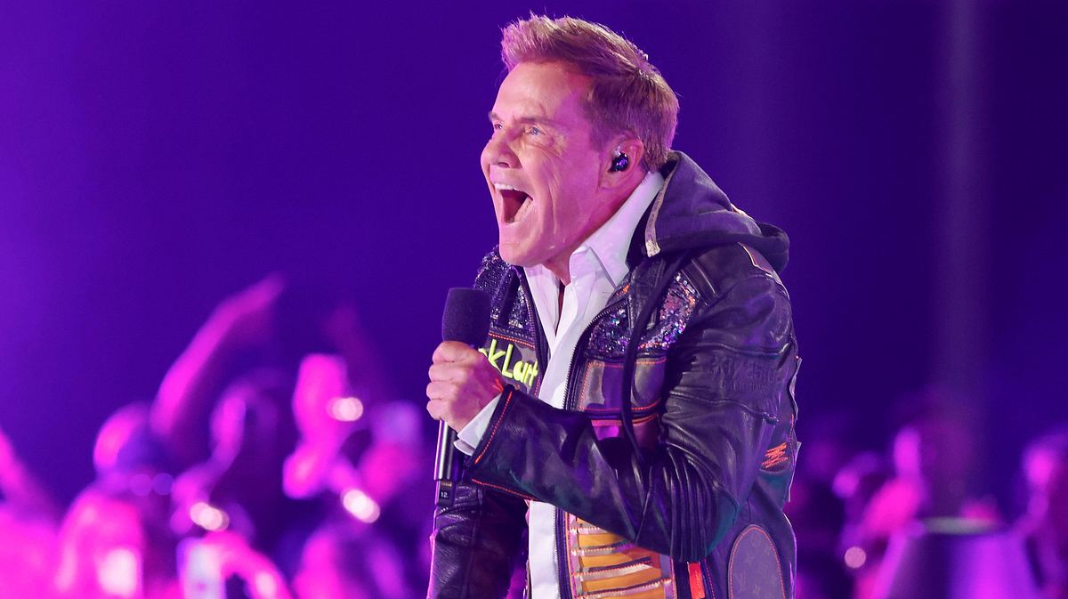 Dieter Bohlen auf der Bühne beim „Schlagerbooom Open Air“. Sein Mund ist weit geöffnet, er hält ein Mikrofon.