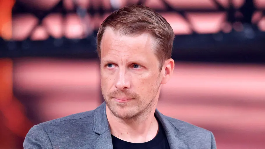 Oliver Pocher kommentiert Amiras vermeintliche Trennung Oliver Pocher blickt mit ernster Miene zur Seite. Er trägt einen grauen Blazer.