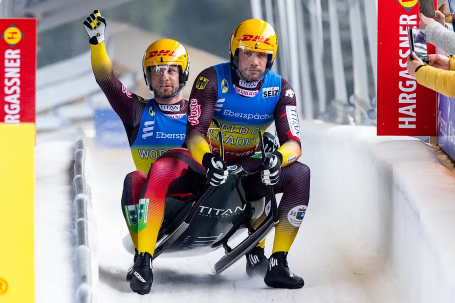 Deutsches Rodel-Duo Tobias Wendl und Tobias Arlt im Doppelsitzer, jubelnd nach einem Lauf auf der Eiskanalbahn.