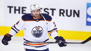 Eishockeyspieler der Edmonton Oilers mit der Rückennummer 29 steht auf dem Eis, trägt ein weißes Trikot und hält den Schläger während eines NHL-Spiels. - Foto: IMAGO/Larry MacDougal Eishockeyspieler der Edmonton Oilers mit der Rückennummer 29 steht auf dem Eis, trägt ein weißes Trikot und hält den Schläger während eines NHL-Spiels. - Foto: IMAGO/Larry MacDougal