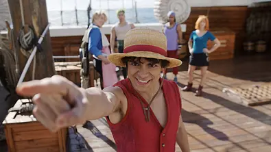 Ruffy zeigt mit dem Finger zum Meer. Seine Crew steht hinter ihm - Foto: Courtesy of Netflix