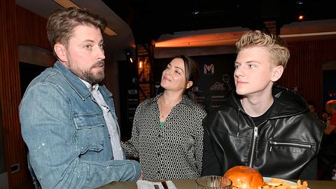 John mit kritischem Gesicht, Emily am lächeln und Oskar an der Bar.  - Foto: RTL / Rolf Baumgartner