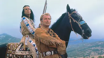 Winnetou 2. Teil: Winnetou (Pierre Brice) sitzt auf seinem Pferd, Old Shatterhand (Lex Barker) steht mit verschränkten Armen davor. - Foto: ZDF/Gerd-Victor Kra