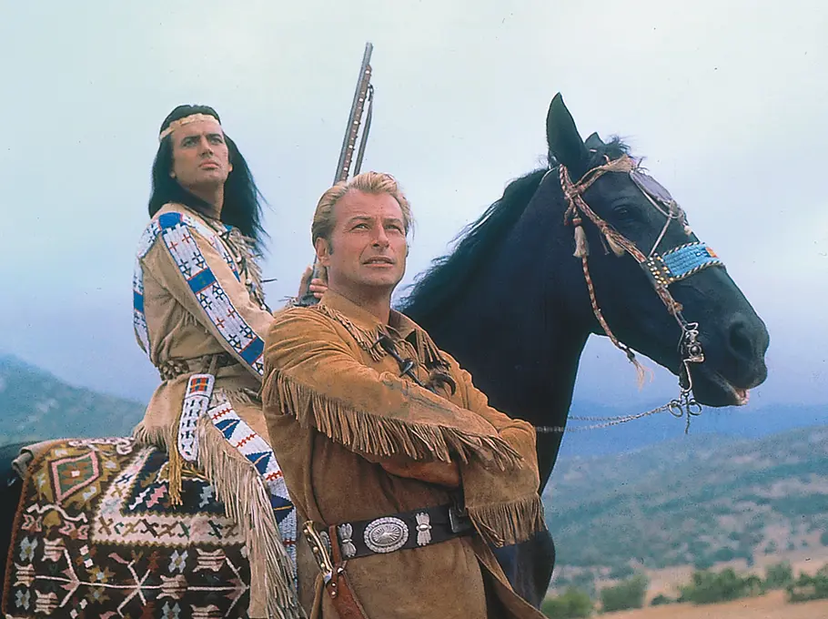 Winnetou 2. Teil: Winnetou (Pierre Brice) sitzt auf seinem Pferd, Old Shatterhand (Lex Barker) steht mit verschränkten Armen davor.