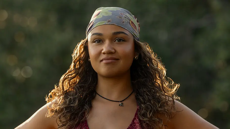 „Outer Banks“, Kiara Carrera Kiara Carrera stützt ihre Arme auf den Hüften ab und lächelt.