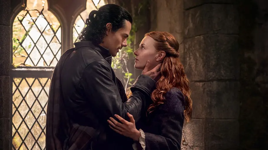 „Outlander: Blood of My Blood“ „Outlander: Blood of my Blood“: Brian Fraser und Ellen MacKenzie in einer Kirche. Er hält seine Hand an ihr Gesicht und die beiden schauen sich tief in die Augen.