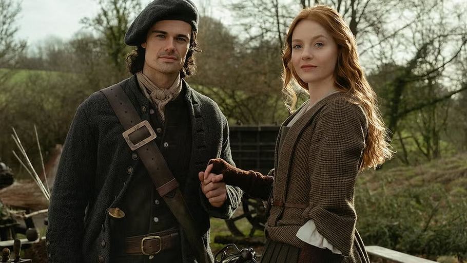 „Outlander: Blood of my Blood“: Brian Fraser und Ellen MacKenzie halten händchen und blicken in die Kamera