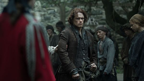 Jamie Fraser mit einem ernsten Gesichtsausdruck und in Handschellen  - Foto: Aimee Spinks/Starz