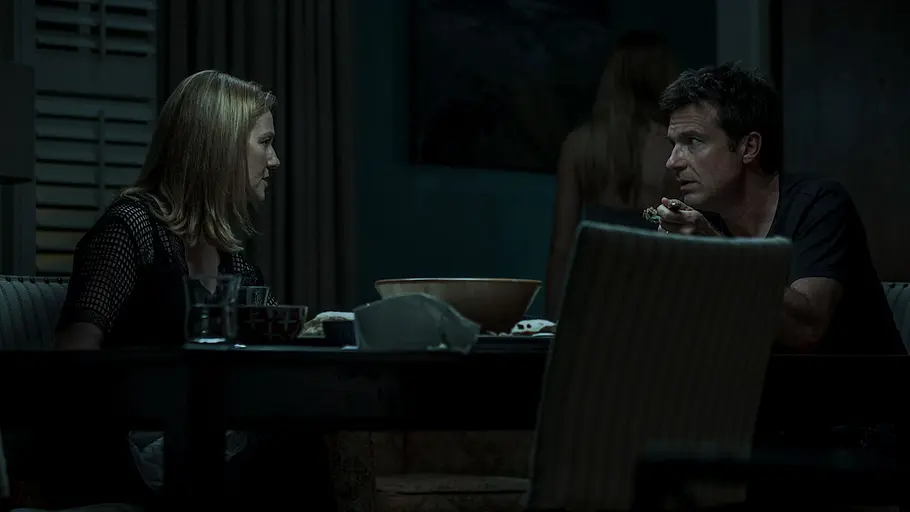Die Schauspieler:innen Laura Linney und Jason Bateman sitzen am Tisch in „Ozark“.