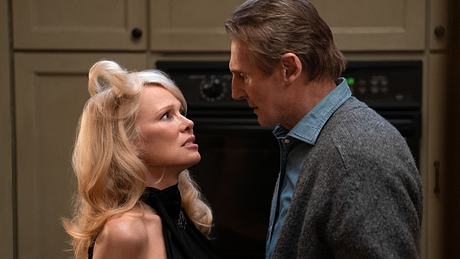 Pamela Anderson und Liam Neeson in „Die Nackte Kanone“. Sie stehen voreinander und schauen sich tief in die Augen, eine Haarsträhne von Pamela Anderson steht stark vom Kopf ab. - Foto: Paramount Pictures