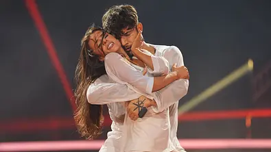 Patricija Ionel und Willi Banner performen eine leidenschaftliche Choreografie auf der „Let’s Dance“-Bühne; beide tragen weiße, halbtransparente Kostüme und stehen eng umschlungen. - Foto: RTL / Stefan Gregorowius