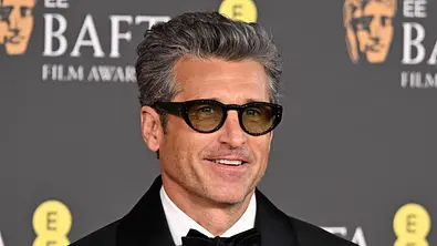 Patrick Dempsey im schwarzen Smoking und Brille bei den BAFTA Film Awards - Foto:  IMAGO / FAMOUS