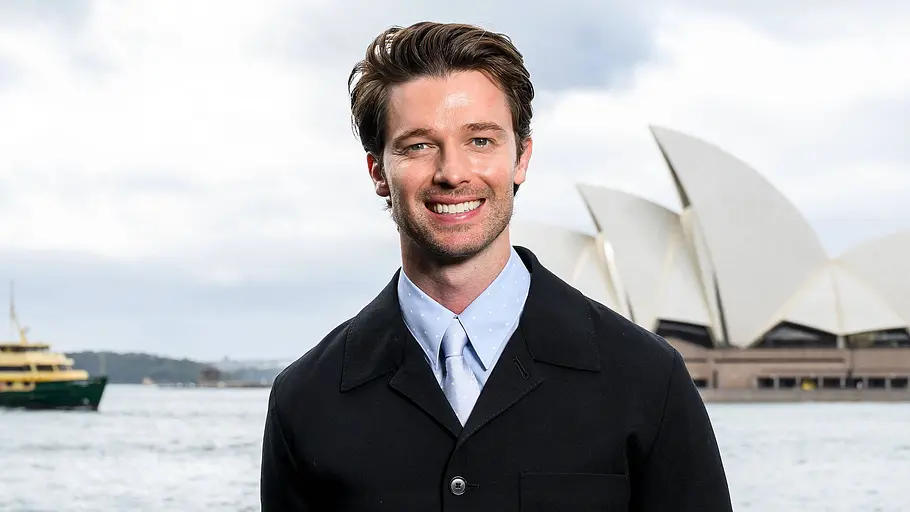 Patrick Schwarzenegger „The White Lotus“-Star Patrick Schwarzenegger steht in Sydney lächelnd vor der Kamera und spielt im „Beach Read“-Film Augustus Everett.