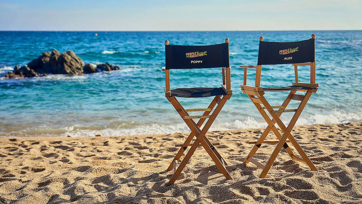 „People We Meet on Vacation“ Hinter den Kulissen von „People We Meet on Vacation stehen zwei Stühle am Strand.
