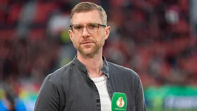 Per Mertesacker mit Mikro in der Hand. - Foto: IMAGO / HMB-Media Per Mertesacker mit Mikro in der Hand. - Foto: IMAGO / HMB-Media