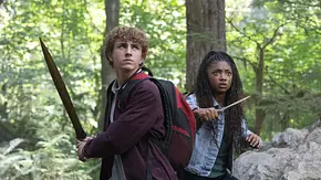 Percy Jackson und Annabeth Chase stellen sich mit Schwertern einer Gefahr in einem Wald. - Foto: Disney+ Percy Jackson und Annabeth Chase stellen sich mit Schwertern einer Gefahr in einem Wald. - Foto: Disney+