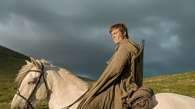 Dunk sitzt mit seinem Schild auf einem weißen Pferd und reitet - Foto: HBO Max
