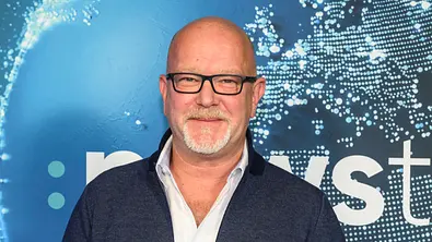 Peter Giesel mit Brille vor einer blauen Fotowand - Foto:  IMAGO / HMB-Media
