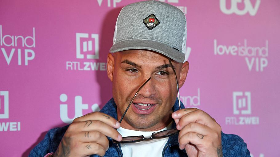 Pietro Lombardi bei der LOVE ISLAND VIP-Kino-Premiere. Er hält eine Sonnenbrille in der Hand und hat den Mund leicht geöffnet. Sein Blick geht nach unten auf den Boden.