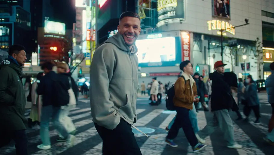 Lukas Podolski wird von Netflix-Kameras begleitet. Lukas Podolski auf einer belebten Straße.