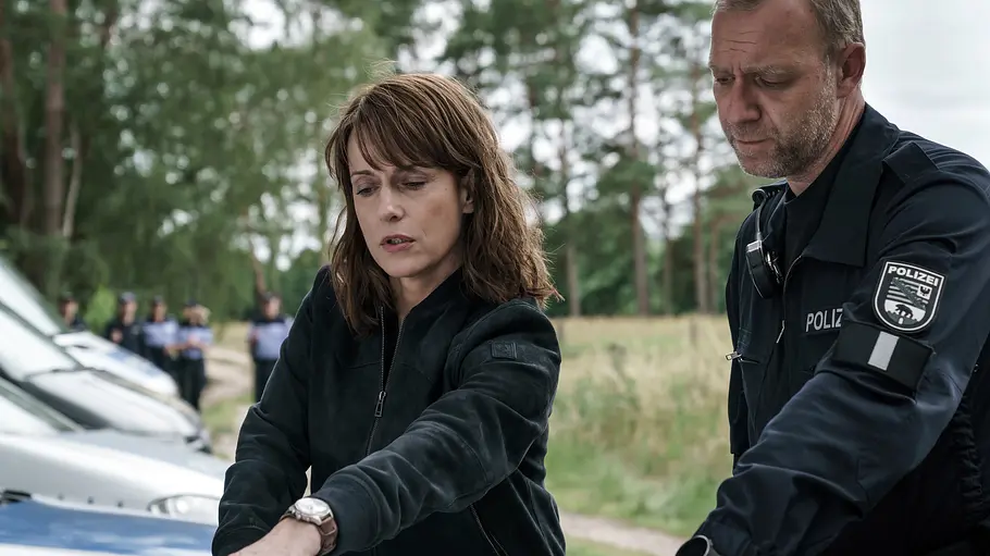 Polizeiruf: Der Verurteilte Claudia Michelsen steht als Ermittlerin Brasch neben einem weiteren Polizisten in der Natur.