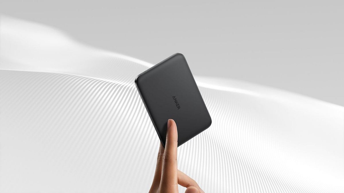 Powerbank Eine Hand hält eine sehr schlanke Powerbank zwischen zwei Fingern.