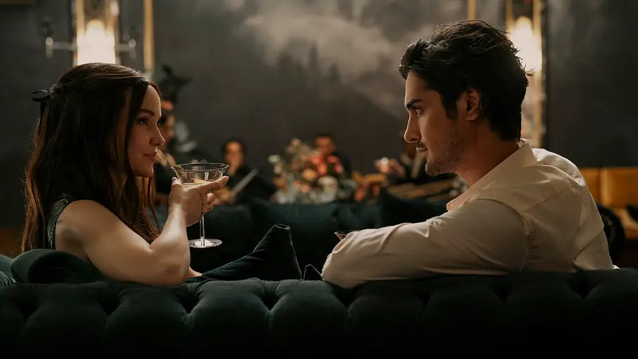 „56 Days“: Ciara Wyse (Dove Cameron) und Oliver Kennedy (Avan Jogia) sitzen mit einem Drink in der Hand auf einer Couch und starren sich intensiv an