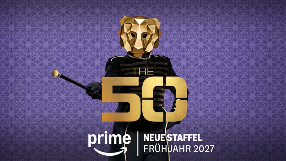The 50 Werbegrafik zur Reality-Show „The 50“ auf Prime Video. Vor einem violett gemusterten Hintergrund steht eine Person in schwarzer Uniform mit einer goldenen Löwenmaske und hält einen Taktstock in der Hand. Im Vordergrund befindet sich das goldene Logo „The 50“ sowie der Hinweis „Neue Staffel Frühjahr 2027“ und das Prime-Video-Logo. Die Gestaltung wirkt geheimnisvoll und inszeniert den Löwen als zentrale Symbolfigur der Show.
