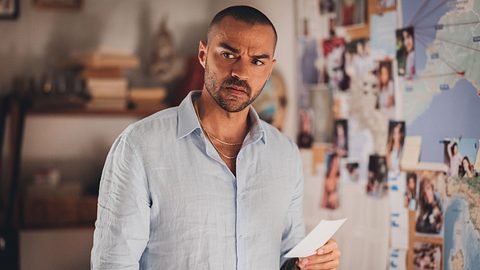 Der Schauspieler Jesse Williams steht vor einer Pinnwand mit Hinweisen und schaut nachdenklich. - Foto: Prime Video