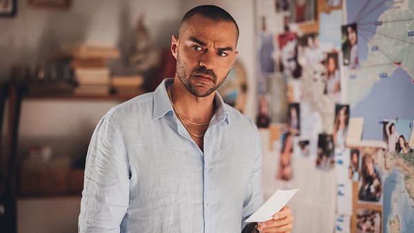 Der Schauspieler Jesse Williams steht vor einer Pinnwand mit Hinweisen und schaut nachdenklich. - Foto: Prime Video