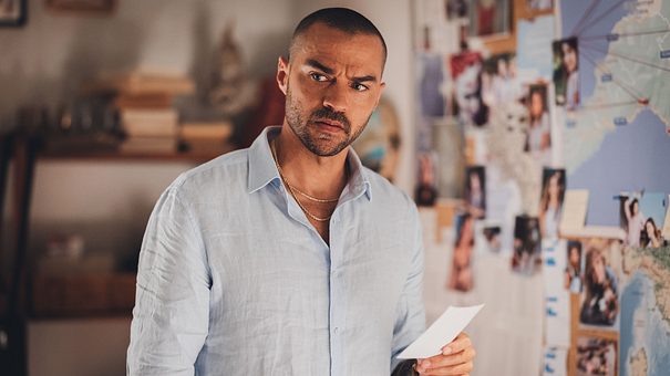 Der Schauspieler Jesse Williams steht vor einer Pinnwand mit Hinweisen und schaut nachdenklich. - Foto: Prime Video