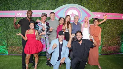 Die Promi Big Brother Kandidaten 2026 posieren vor einer grünen Wand mit „Promi Big Brother“-Logo. Zwei Männer knien vor der Gruppe. - Foto: IMAGO / BOBO Die Promi Big Brother Kandidaten 2026 posieren vor einer grünen Wand mit „Promi Big Brother“-Logo. Zwei Männer knien vor der Gruppe. - Foto: IMAGO / BOBO