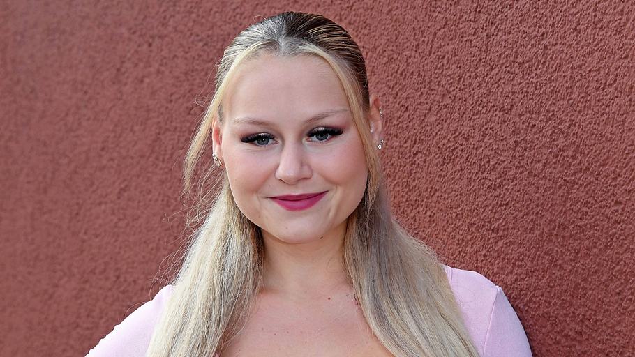 Sarah-Jane Wollny steht vor einer Hausmauer