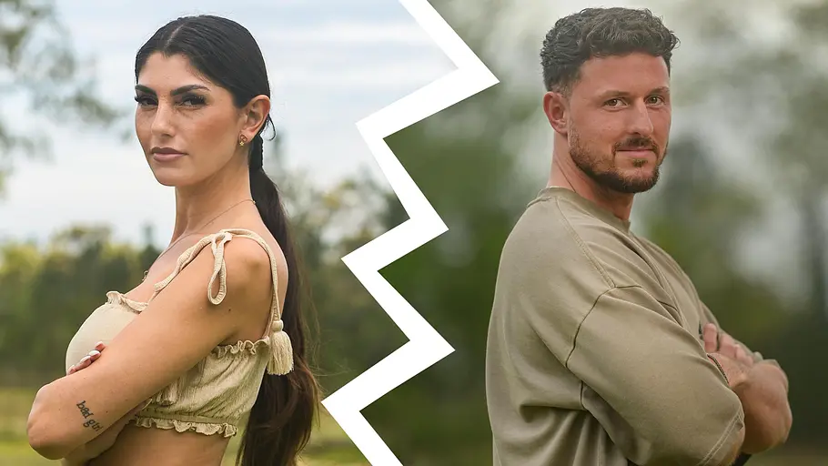 Yeliz und Jannik Porträt eines Mannes und einer Frau vor einem unscharfen Naturhintergrund. Zwischen ihnen verläuft ein großer weißer Zickzack-Riss, der eine Trennung symbolisiert. Beide stehen mit verschränkten Armen Rücken an Rücken und blicken selbstbewusst in die Kamera. Die Frau trägt ein beiges zweiteiliges Outfit mit langen dunklen Haaren, der Mann ein beigefarbenes Shirt. Die Aufnahme vermittelt den Eindruck eines ehemaligen Paares.