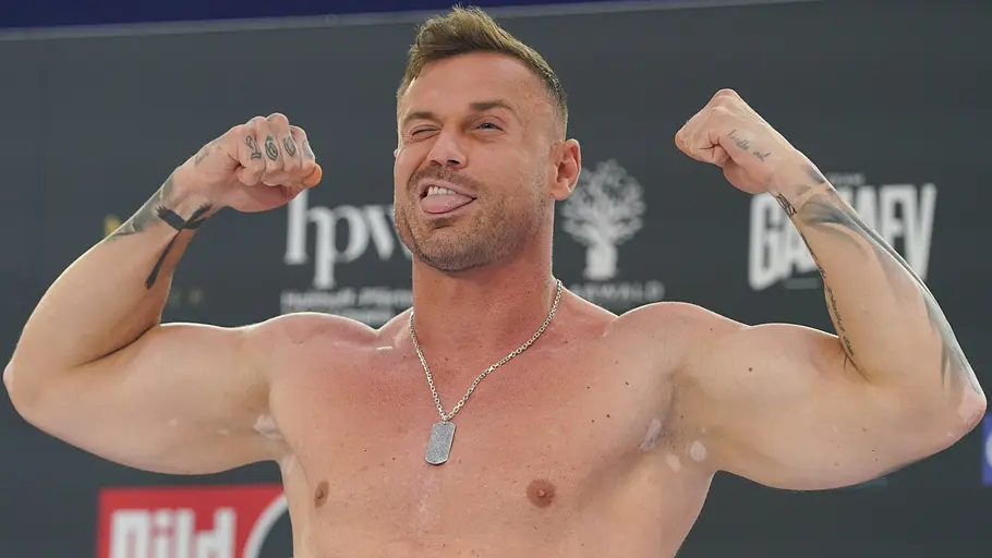 War in schon fast allen Reality-TV-Shows: Chris Broy. Chris Broy zeigt seine Muskeln und zwinkert und hat die Zunge herausgestreckt.