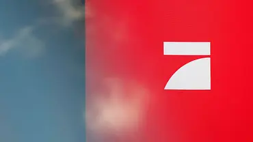 ProSieben-Logo auf rotem Hintergrund, links unscharfer Bereich in Blau- und Grautönen - Foto: IMAGO / Panama Pictures ProSieben-Logo auf rotem Hintergrund, links unscharfer Bereich in Blau- und Grautönen - Foto: IMAGO / Panama Pictures
