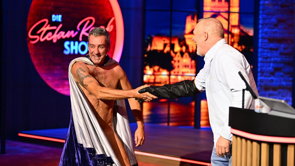 Stefan Raab schüttelt dem Penis-Puppenspieler die Hand.