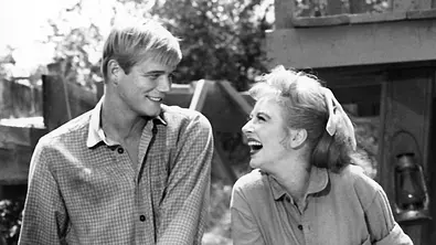 Roger Ewing steht neben Schauspielkollegin Amanda Blake. Beide strahlen glücklich. - Foto: IMAGO / Allstar