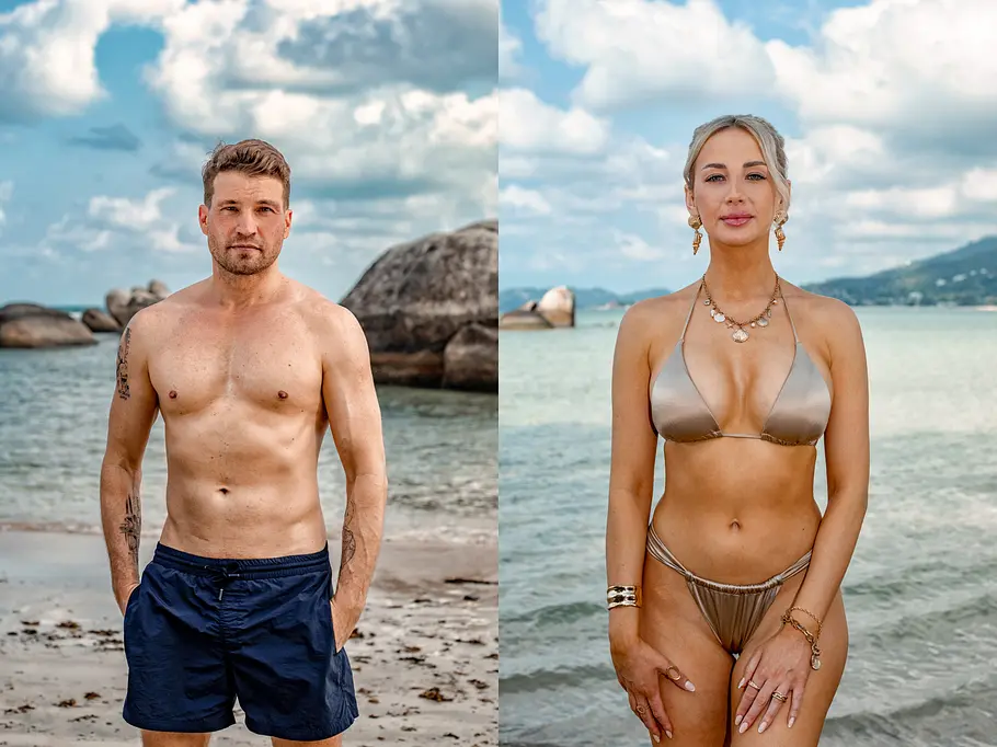 AYTO Ein Mann mit kurzen Haaren in dunkelblauer Badehose und eine Frau mit blonden Haaren im goldfarbenen Bikini stehen jeweils am Strand vor türkisblauem Wasser und Felsen. Beide blicken direkt in die Kamera, sommerliche Atmosphäre, leichter Wolkenhimmel im Hintergrund.