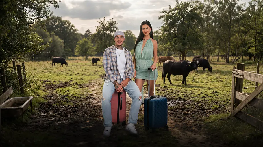 Reality-Pärchen Tano (25) und Anna (26) mit Koffern vor einer Kuhweide.