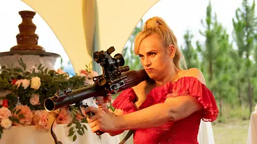 Rebel Wilson im Film „Bride Hard“ mit einem Granatwerfer. - Foto: Constantin Film Distribution GmbH Rebel Wilson im Film „Bride Hard“ mit einem Granatwerfer. - Foto: Constantin Film Distribution GmbH