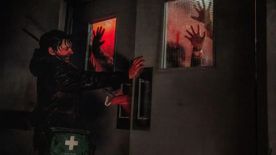Resident Evil Zach Cregger Der Protagonist von Resident Evil hält eine Tür zu, hinter der Zombies mit ihren Händen dranschlagen