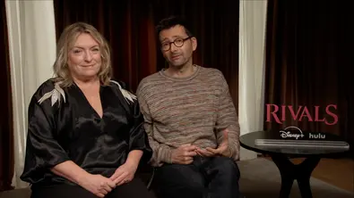 David Tennant und Claire Rushbrook neben einem Schild mit dem „Rivals“-Logo.  - Foto: Disney+ / Hulu / TV Movie