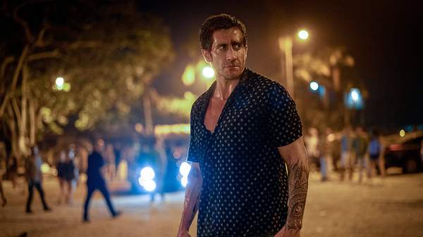 Jake Gyllenhaal steht auf einem Platz bei Nacht. Hinter ihm stehen mehrere Menschen. Er trägt ein dunkelblaues Hemd mit weißen Punkten. - Foto:  IMAGO / ZUMA Press