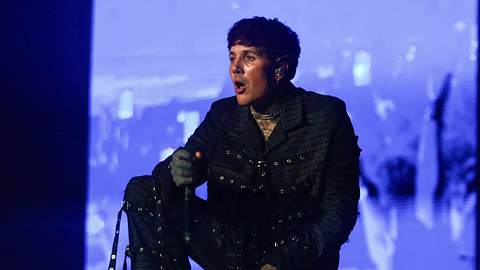 Oliver Sykes kniend auf der Bühne mit einem Mikrofon in der Hand - Foto:  IMAGO / Fotoarena