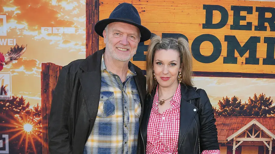 Roland Heitz und Janina Korn Roland Heitz mit Hut und Janina Korn in schwarzer Lederjacke posieren vor einer Werbewand mit RTLZWEI-Logos.