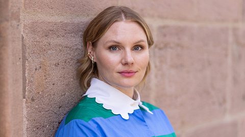 Schauspielerin Rosalie Thomass, die gerade für den Franken-„Tatort“ bestätigt wurde, lehnt an einer Wand und blickt in die Kamera. - Foto: BR / Markus Konvalin