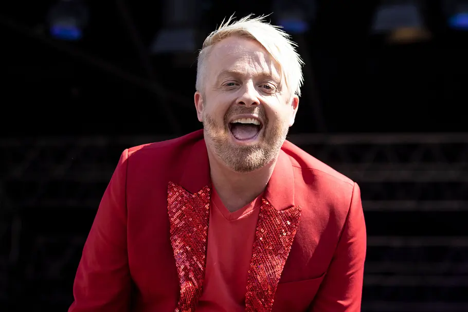 Ross Antony Ross Antony in einem roten Anzug lacht auf dem roten Teppich in die kamera