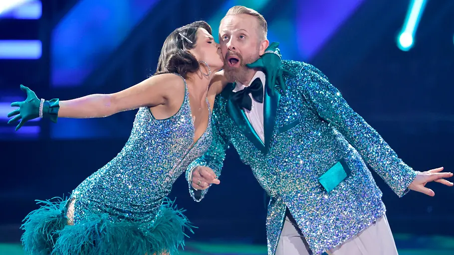 Ross Antony und Mariia Maksina bei Let’s Dance auf dem Tanzparkett Ross Antony und Mariia Maksina tanzen bei Let’s Dance in glitzernden Outfits, während sie eine Tanzfigur auf der Bühne ausführen.
