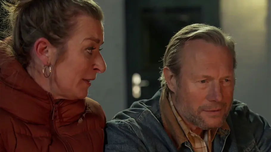 „Rote Rosen“ Folge 4393, 7. Oktober 2026 Rote Rosen-Vorschau, Folge 4393: Carla in einer rotbraunen Steppjacke blickt zu Michael, der neben ihr sitzt und eine Jeansjacke über einem karierten Hemd trägt.